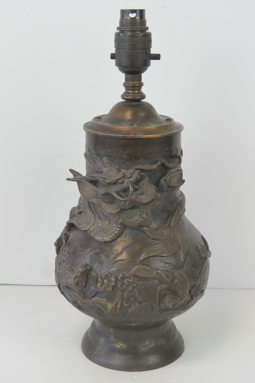 A 19th century bronzed brass Oriental vase profusely decorated in relief with dragons upon,