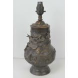 A 19th century bronzed brass Oriental vase profusely decorated in relief with dragons upon,