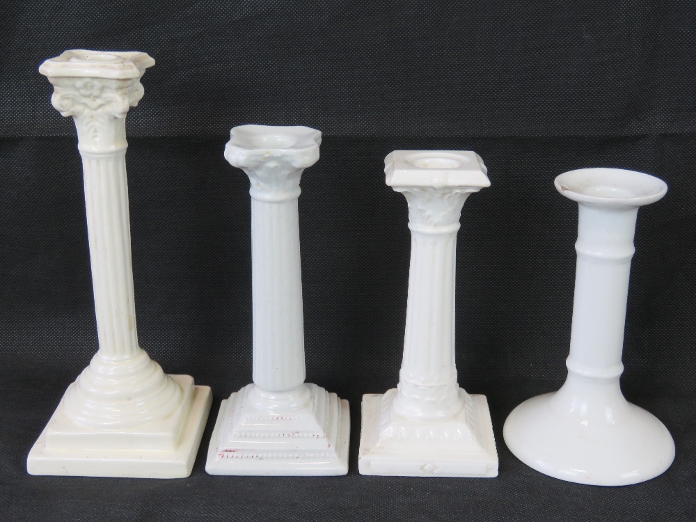 Four white pottery candlesticks, includi