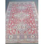 A Wilton bordered rug with three central medallions, in red and cream, 200cm x 142cm.