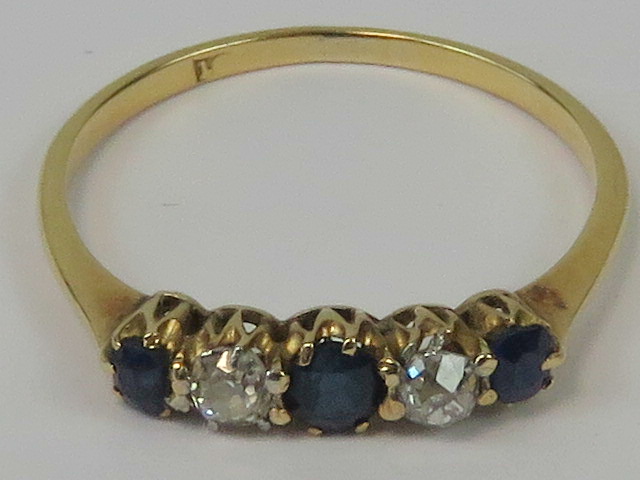 An 18ct gold diamond and sapphire ring, three graduated sapphires of good royal blue colour,