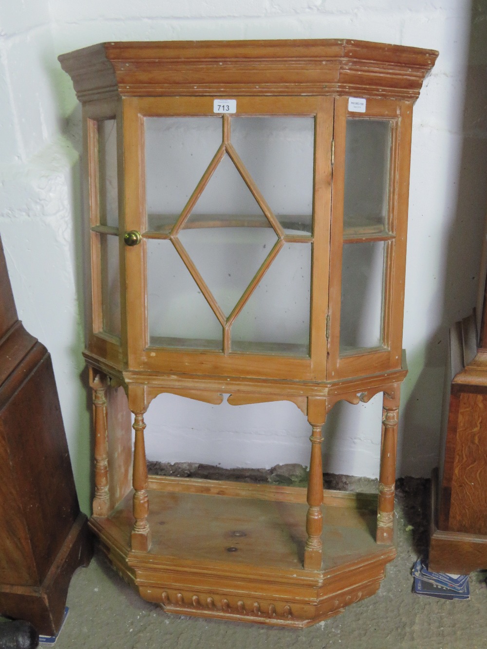 A wall hanging pine lazed display cabinet with single door and open shelf under, 70cm wide.