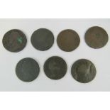 A 1722 George I half penny coin and two worn George I half penny coins.