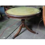 A reproduction Regency style tilt top circular table having inset leather surface,
