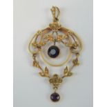 A delightful Edwardian 9ct seed pearl and amethyst pendant of floral form having articulated swag