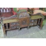 A Victorian stained oak overmantle having central smokers cabinet flanked by twin green man mask