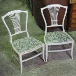 A pair of low painted cream chairs of small proportions.