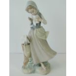 A Lladro figure of a girl with two doves, standing 22cm high.