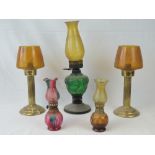 An oil lamp having green glass reservoir and amber glass chimney, together with two small oil lamps,