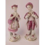 A pair of Continental porcelain figurines being male and female in pink and white outfits,