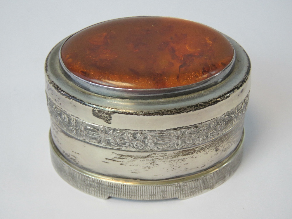 A HM silver trinket box having large oval Baltic amber cabachon to lid and raised floral bouquet