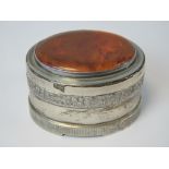 A HM silver trinket box having large oval Baltic amber cabachon to lid and raised floral bouquet