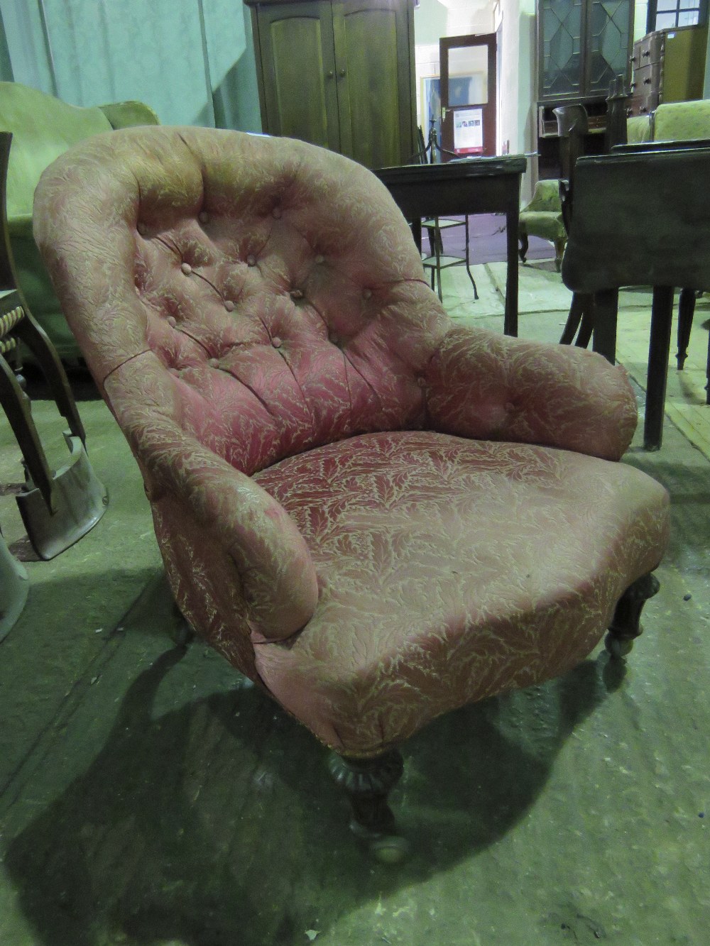 A late Victorian spoon back low fireside ladies chair raised over mahogany legs.