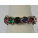 A vintage rose metal 'REGARD' ring having claw set coloured paste stones (Ruby, Emerald, Garnet,