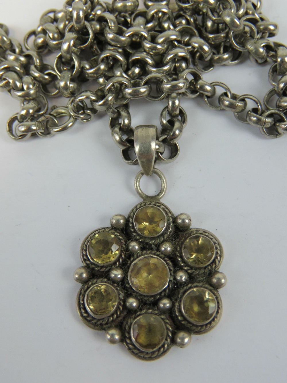 A silver daisy cluster pendant set with citrines.