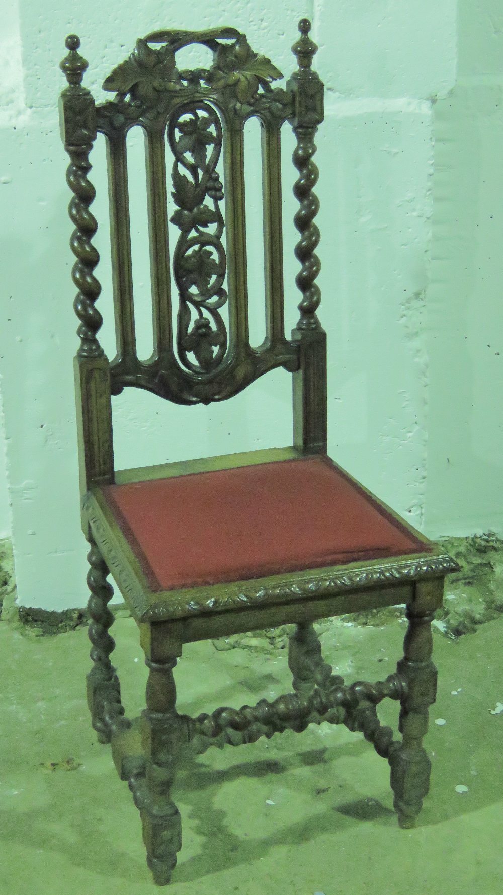 A Victorian Carolian revival single chair having pierced and carved decoration and raised over