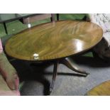 A reproduction mahogany oval low centre table raised over quatreform base, 122cm in length.