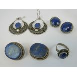 A pair of large white metal filigree half hoop style earrings having central oval lapis lazuli