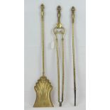 A large size brass companion set comprising tongs, poker and shovel.