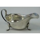 A large HM silver sauce boat having pie crust edge and raised over three outswept feet,