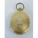 A Victorian yellow metal memorial locket each side opening to reveal gazed compartment having hair