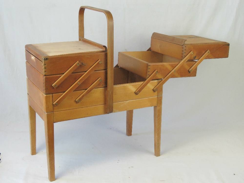 A vintage cantilever sewing box having three tiers and over handle,