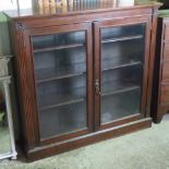 An Edwardian plain mahogany twin glazed door bookcase opening to reveal adjustable shelves within,