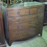 An early 19th century bow fronted two over three chest of drawers, 106cm wide.