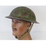 A WWII British military issue helmet, dated 1940 with original liner and chinstrap.