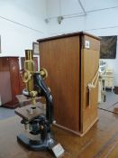 A REICHERT WIEN MONOCULAR MICROSCOPE COMPLETE WITH CASE AND LENS.