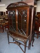 AN EDWARDIAN MAHOGANY GLAZED BOOKCASE ON SERPENTINE FRONT STAND. W.107 x H.196cms.