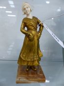 AN EARLY 20th.C.GILT BRONZE AND CARVED IVORY FIGURE OF A DUTCH GIRL ON A STEPPED MARBLE BASE.