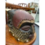 AN AFRICAN CARVED WOOD HEAD DRESS MASK WITH POLYCHROME DECORATION AND APPLIED HIDE AND COWREY