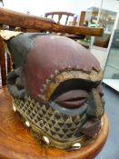 AN AFRICAN CARVED WOOD HEAD DRESS MASK WITH POLYCHROME DECORATION AND APPLIED HIDE AND COWREY