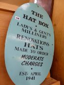 A HAND PAINTED SIGN THE HAT BOX.