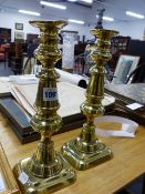 A PAIR OF VICTORIAN BRASS CANDLESTICKS.