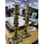 A PAIR OF VICTORIAN BRASS CANDLESTICKS.