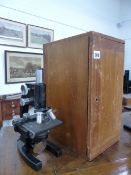 A BAUSCH & LOMB BLACK LACQUERED MONOCULAR MICROSCOPE WITH A MAHOGANY CASE.