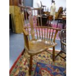 AN EARLY ASH AND ELM STICK BACK ARMCHAIR WITH SADDLE SEAT AND SHAPED CREST RAIL.