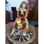 AN ANTIQUE AND LATER WAX HEAD GYPSY DOLL ON A CARVED WALNUT BASE.