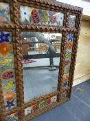 AN UNUSUAL FOLK ART EGLOMISE FRAMED MIRROR.