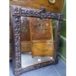 A VICTORIAN CARVED OAK MIRROR WITH HERALDIC CREST, THE FRAME DECORATED WITH OAK LEAVES AND ACORNS.