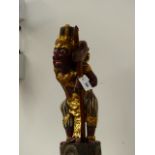 A JAVANESE FIGURE OF A DEMON WARRIOR MOUNTED WITH KRIS WITH WAVY DAMASCENE BLADE CONTIANED IN WOOD
