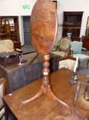 AN EARLY YEW WOOD TILT TOP LAMP TABLE ON TRIPOD SUPPORTS.