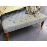 A LARGE BUTTON UPHOLSTERED FOOTSTOOL ON TURNED LEGS. L.105 x W.69cms.