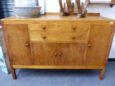 A HEAL'S GOLDEN OAK SIDEBOARD WITH TWO CENTRAL DRAWERS OVER CUPBOARD DOORS WITH TURNED WOODEN