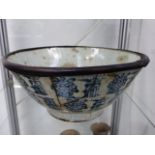 A LARGE ORIENTAL BLUE AND WHITE POTTERY BOWL WITH BAMBOO RE-ENFORCED RIM. 26CM DIAMETER