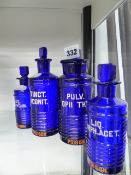 A GROUP OF FOUR RARE BLUE GLASS APOTHECARY POISON BOTTLES WITH ENAMELLED LABELS.