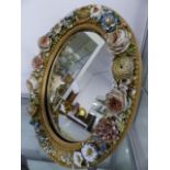 A PAIR OF CONTINENTAL PORCELAIN FLOWER ENCRUSTED OVAL FRAME EASEL BACK MIRRORS WITH POLYCHROME