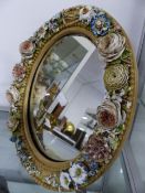 A PAIR OF CONTINENTAL PORCELAIN FLOWER ENCRUSTED OVAL FRAME EASEL BACK MIRRORS WITH POLYCHROME